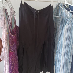 Svart kjol - Knälång svart kjol med snörning där fram. 