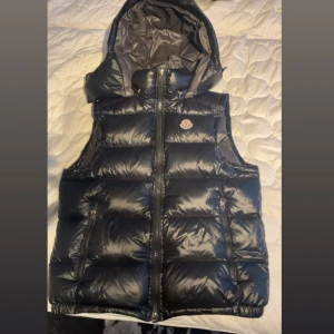 Svart moncler maya väst jacka  - Passar lika bra som storlek S eller M, i bra skick, säljer denna varan eftersom jag ej gillar sådana stilar för endast 1500kr.   