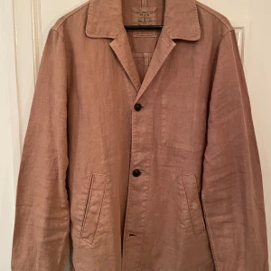Snygg brun-beige overshirt / överskjorta i linne - En superfin overshirt / överskjorta i linne från märket MJB. Tyget andas otroligt bra och passar utmärkt på sommaren och våren.   Plagget är ej använd då den är för liten för mig då jag normalt har storlek L. Priset är prutat och klart.