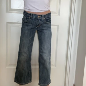 Mörkblå utsvängda jeans  - Mörkblåa jeans litet hål på knät 
