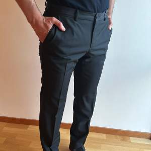 Svarta kostymbyxor från Lab.  Sparsamt använda, mycket fint skick.  Tvättade på kemtvätt inför försäljningen.  Storlek: 48.  Material: 100% ull.   