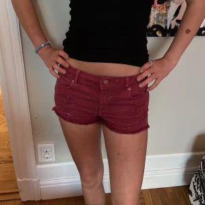 Röda jeansshorts  - Vinröda jeansshorts med revor