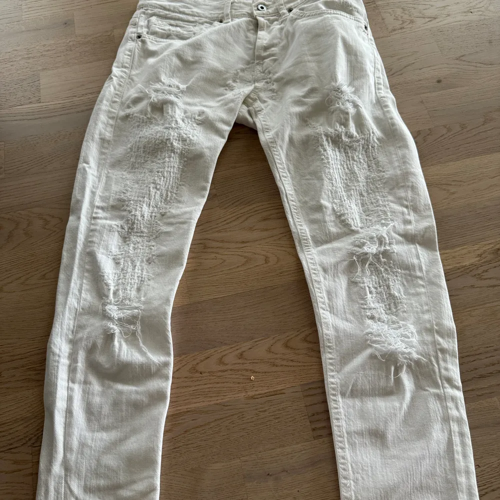 Säljer nu dessa Vita Dondup jeans med massvis med slitningar! Jeans modellen är George och är slimfit. . Jeans & Byxor.