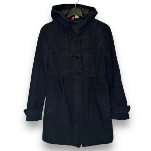 Duffelkappa - Använd men fortfarande i fint skick! Två fickor i fram. Stängs med dragkedja och spännen.