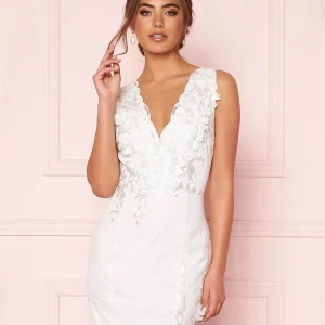 Bröllopsklänning Moments New York - Brudklänning, stl. 42 (M), Helt NY!   Märke: Moments New York Färg: White  Storlek: 42 Material: Foder: 100% polyester. Spets: 100% polyester.  Fantastisk brudklänning utsmyckad med 3D-blommor och broderi från MOMENTS NEW YORK. 