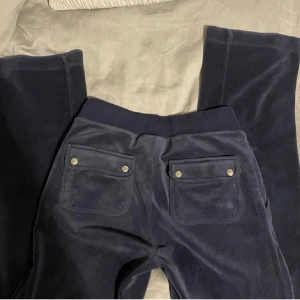 Juicy couture  - As snygga juicy couture byxor i mörkblått. Säljer på grund av att jag behöver pengar. Pris går att diskutera💕 Tveka inte att höra av dig vid frågor! (Lånade bilder)