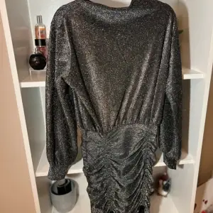 En grå glittrig klänning från H&M som sitter åt i rumpan och har även en fin liten ”öppning” i ryggen (kolla bild)♥️ Storlek: S ♥️♥️♥️