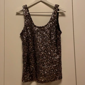 Glittrig linne - Fint glittrigt linne i brun/guldfärg Köpt på Vinted men i bra skick!  Säljer då det tyvärr inte passa mig