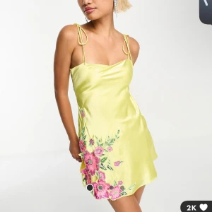 Satin klänning  - En gul satinklänning med blommiga paljett detaljer och öppen rygg. Jätte fin men för kort för mig. Köptes för 1209kr 