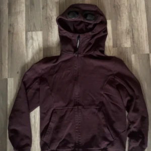 C.P Company Fleece Goggle Full Zip Hoodie - C.P Company Fleece Goggle Full Zip Hoodie!  Strl M sitter som en S  Färg: Röd (har blivit lite mer åt de vinrödare hållet) Ny pris: 3300kr Mitt pris: 1200kr