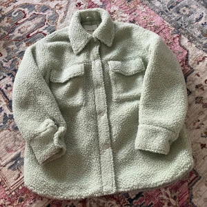 Teddy jacka från Monki - En fin ljusgrön jacka från Monki, passar perfekt till våren och tidig höst!  Skicket är som ny, då den endast är använd ett fåtal gånger
