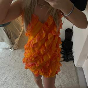 Jätte söt orange volang klänning från NA-KD i storlek 34. Använd en gång, bra skick. Skriv om ni vill ha fler bilder eller vid frågor 💛