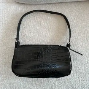 Svart mönstrad ormskin väska från Ginatricot. En perfekt handväska för en dag på stan 💃🏼.  Använd men väldigt bra skick!