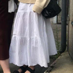 Omlottkjol i Broderie Anglaise - Säljer nu min fina omlottkjol från Lindex! Superfin och skön på sommaren och med fina broderie anglaise detaljer. 100% bomull. Kjolen knäpps på insidan i midjan av en knapp, där har jag gjort ett eget litet hål, men det är inget som syns.
