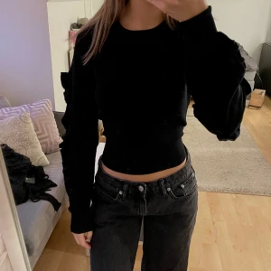 Tröja med volanger - Säljer min ribbstickade tröja/blus från Bikbok med volanger längs ärmarna. Den är i stl S men passar XS-M pga det stretchiga tyget, jag är 170 cm för referens. Passar både till vardags och finare tillfällen. Skriv för fler bilder❤️‍🔥