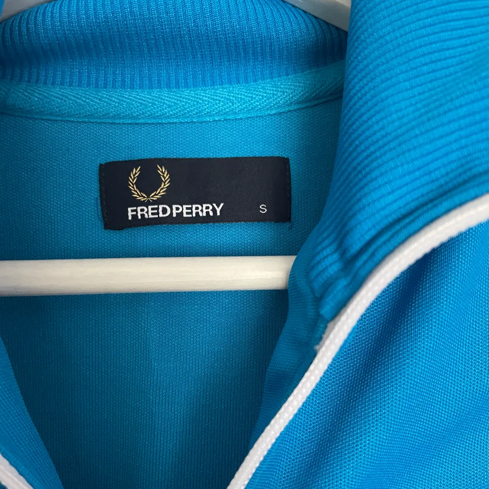 Säljer denna zip tracksuit från Fred Perry, blå färg med två vita linjer på båda ärmarna Bra skick🌟. Hoodies.