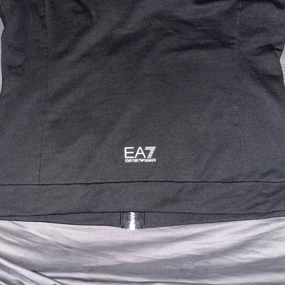 EA7 zip-tröja (dam) i storlek S. Använd en enda gång. Köptes på JD Sports för 1299:-. Kan mötas upp eller frakta.. Hoodies.