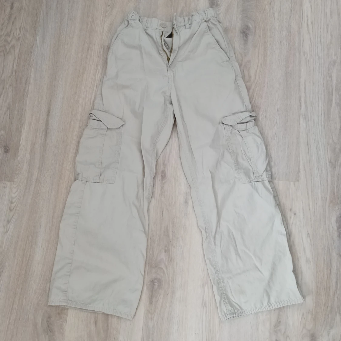 Ett par beiga cargo byxor i bra skicka. 