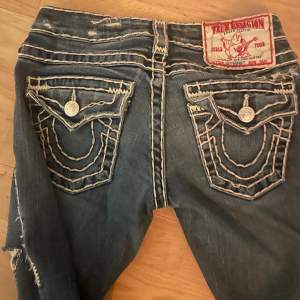 Säljer mina älskade true religion jeans, köpt här på Plick❤️ säljer billigt då de finns ett litet håll på baksidan av benet som man inte tänker på  Innerbenslängd: 75 midjemått tvärsöver:35