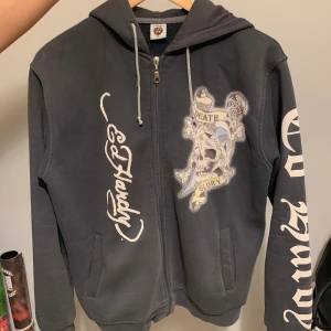 Ed Hardy hoodie/kofta - Vintage grå Ed Hardy hoodie med dragkedja. Diamanter/rhinestones på både framsidan och baksidan. Jättefint skick. Kontakta vid frågar eller fler bilder!