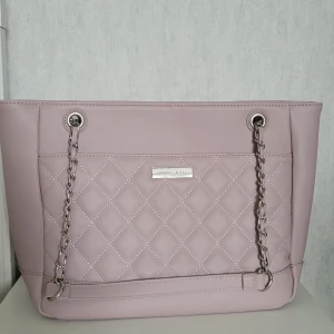 Väska från Annafield -  Säljer denna snygga väskan som är helt ny men utan prislapp. Tryck gärna på köp nu. Färgen är syrenlila. 25 sm i höjd och 39 cm i bredd