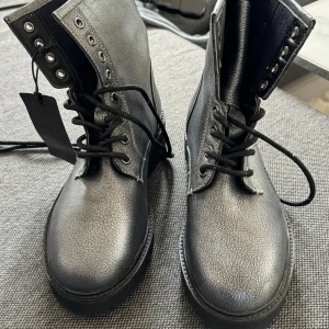 Boots från Blauer  - Snygga silvriga boots från Baluer, syns i mängden. Aldrig använda med lapp kvar! Skorna är i storlek 37 och kostade nya 1500:-  