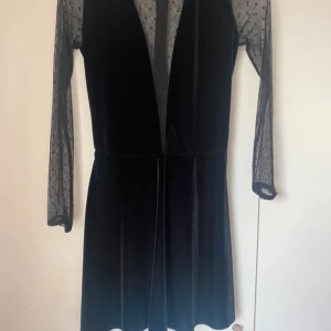 Klänning  - Klänning med djup genomskinlig urringning och genomskinlig rygg.