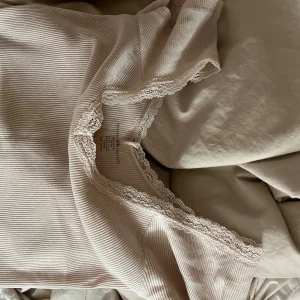 brandy topp - en ljusrosa brandy melville topp/tee med spets. 
