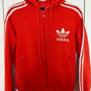 Adidas hoodie - Jättefin adidas hoodie som är så skön att ha på sig! Den är en blandning av en röd och orange färg! ❤️ perfekt till träning eller vardags! Skriv vid funderingar, pris kan diskuteras 
