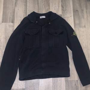 En snygg mörblå overshirt av Stone Island. Ärvt den så allt den kom med saknas såsom extra knappar. I toppskick finns ej en enda skråma på den. Vid frågor hör av dig!