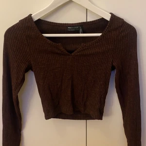 Ribbad brun topp från ASOS - En jättegullig kort topp i brun färg som är ribbad, den är i stolek 34(petite) och är rätt liten i storleken. Säljer den då den inte kommit till användning någon gång.