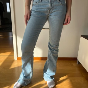 Low Waits jenas - Här säljer vi ett par snygga låg midjade jeans i en ljus blå färg. Dem har innerbenslängden 81 cm och midjan mätt rakt över är 40 cm! 
