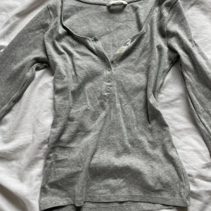 Grå långärmad tröja!🤍 - Det är ett stretchit material, använd 2 gånger. Köpt på H&M, anledning till försäljning: lite kort i armarna för mig. Sitter annars jätte bra på!🤍 går bra o skriva om ni vill ha fler bilder!