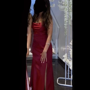 Röd balklänning - Röd silkeklänning till bal eller bröllop. Perfekt skick, annvänt endast en gång. Midja: 65cm. Jag är 160cm. Klänningen har slits och knyt band vid ryggen. Köp tillsammans med den lila klänningen för att få båda för 1000kr.