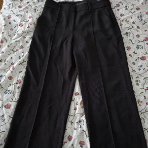 Svarta kostymbyxor - Raka kostymbyxor från STOCKH LM i stolek 40. Söm i mitten av benen. Mycket bra skick. Material: polyester & elastan. Har två framfickor. 