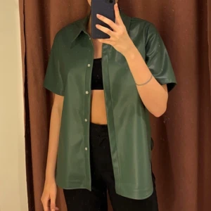 Skinn topp - Snygg grön kortärmad topp från Ginatricot! Använd fåtal gånger.