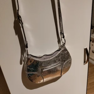 Silvrig handväska  - Supercool silvrig handväska. Lagom stor för mobil, nycklar, plånbok osv.. nyskick ❤️
