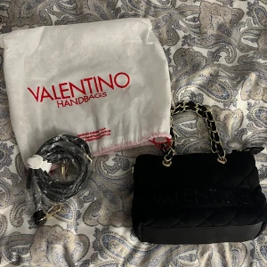 Handväska - Säljer en liten gullig handväska från valentino äkta i svart och guld. Oanvänd