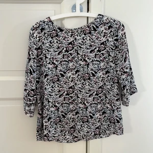 Finn topp från Zoul (MQ) - Fin topp i flera färger (vitt, svart, rosa och ljusblå) med halvlång ärm i polyester. Stl 36