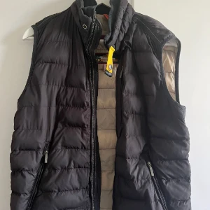 Parajumper väst - Parajumper väst i storlek M, använt i 2 år, lite små hål som man ser på bilden, men annars gott skick. Kan skicka fler bilder. Den är äkta. Har ej kvar kvitto! Köpt för 4000, men säljer för 850kr.