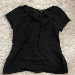 Svart blus - Jättegullig svart blus i nyskick med knyte framtill. Perfekt blus till sommarn💓💓