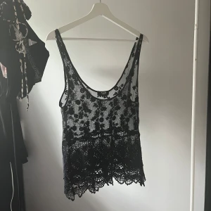 Topp svart spets - Supersnygg spetstopp, storlek XS men skulle säga att den mer är som en M då den har väldigt låg urringning