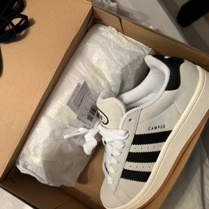 Adidas campus 00s  - Hej! Säljer ett par i princip nya adidas campus skor i beige färg. Extremt fina. Använda två gånger och tyvärr insett i efterhand att de nog är för små och därav säljer jag dom. Medföljs kartong + svarta skosnören. Köparen står för frakten. 