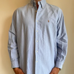 Ralph Lauren  - Blå Ralph Lauren skjorta i storlek 15,5-33 vilket motsvara ca L. Skjortan är i fint skick utan några skavanker. Modellen är 186 cm lång. Orginalpris ca 1500 kr och nu endast 499. 