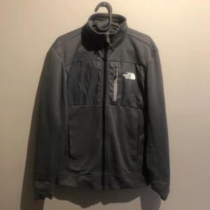 The North Face full zip Jacket - En gråblå North face full zip fleece jacka i storlek XS, den är i 9/10 skick eftersom att trycket har försvunnit lite granna som knappt är synligt 