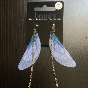 Guldfärgade & lila hängande örhängen, trollslända, bohemisk, boho, guld - Guldfärgade örhängen med ljuslila vingar. Längd (kedja): 8,5 cm.