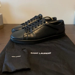 Saint Laurent Skor - SJUK STEAL! Helsvarta Yves Saint Laurent Skor i riktigt fint skick! Vid köp ingår originaldustbag och en till mindre dustbag med extra originela skosnören i. Normala i storlek (True to size).