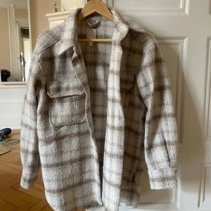 Rutig kappa - Beige/vit flanellkappa i jätteskönt material. Passar perfekt till våren och hösten. 