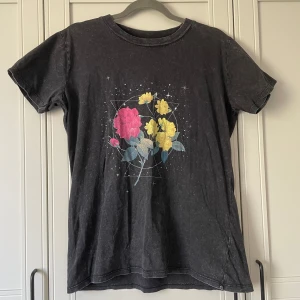 T-shirt med tryck - Längd 70 cm, storlek M. Använd 1 gång och tvättad. Stentvättad T-shirt med blomtryck. 