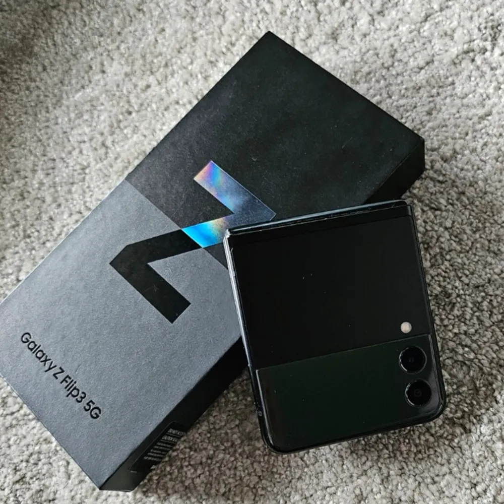  Använd – i gott skick Galaxy Z Flip3 5G (SM-F711B) Färg: svart 128GB i lagringsminne 8GB ramminne. Finns en repa på stora skärmen, inget som påverkar funktionen. Bra batteri.  Original kartong medföljer, se bilder.  . Övrigt.